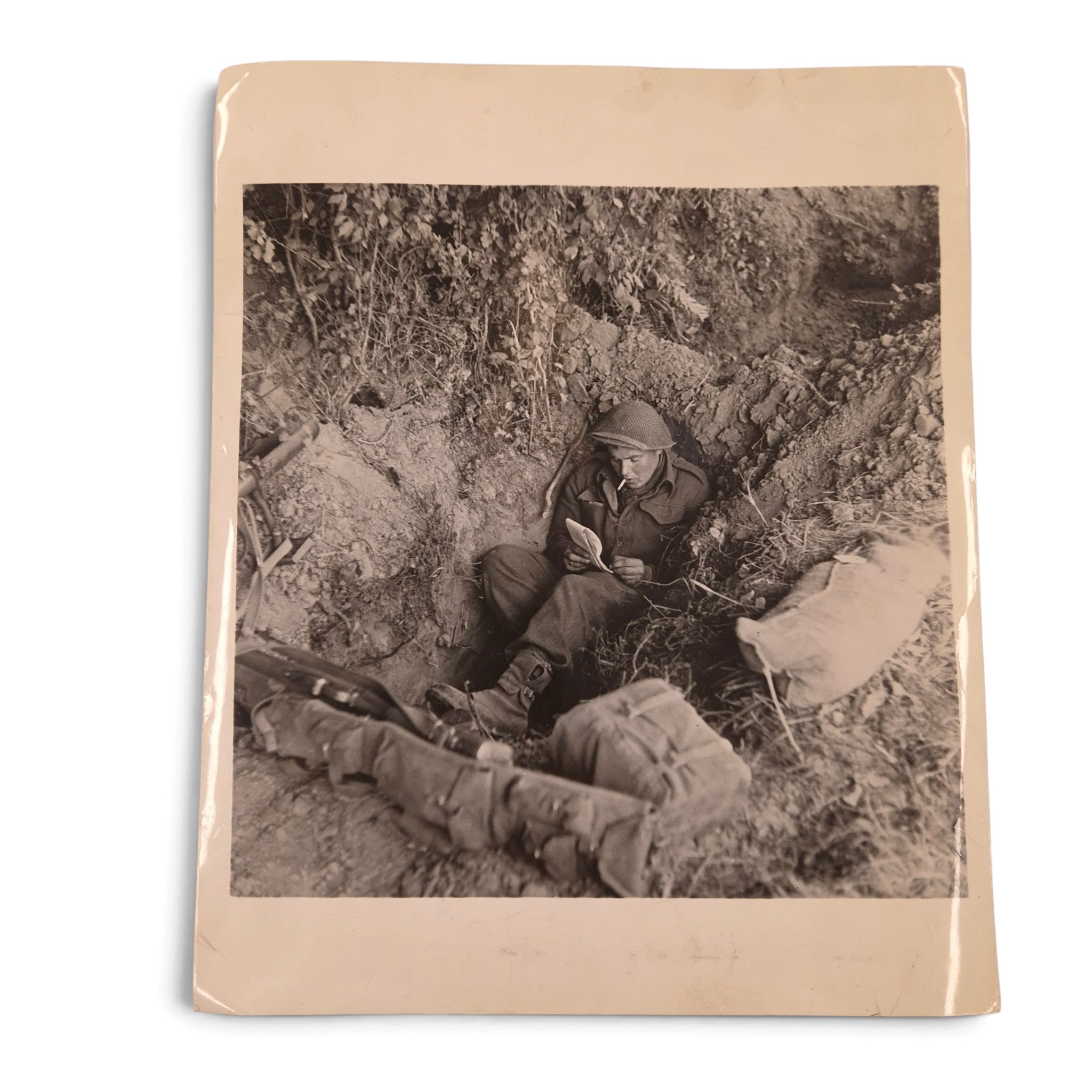 British Press Photograph – Soldier writing from a foxhole, Normandy 1944